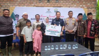 Bupati Muaro Jambi menyerahkan simbolis bantuan bedah rumah kepada warga Desa Sakean. (Foto: Diskominfo Pemkab Muaro Jambi)