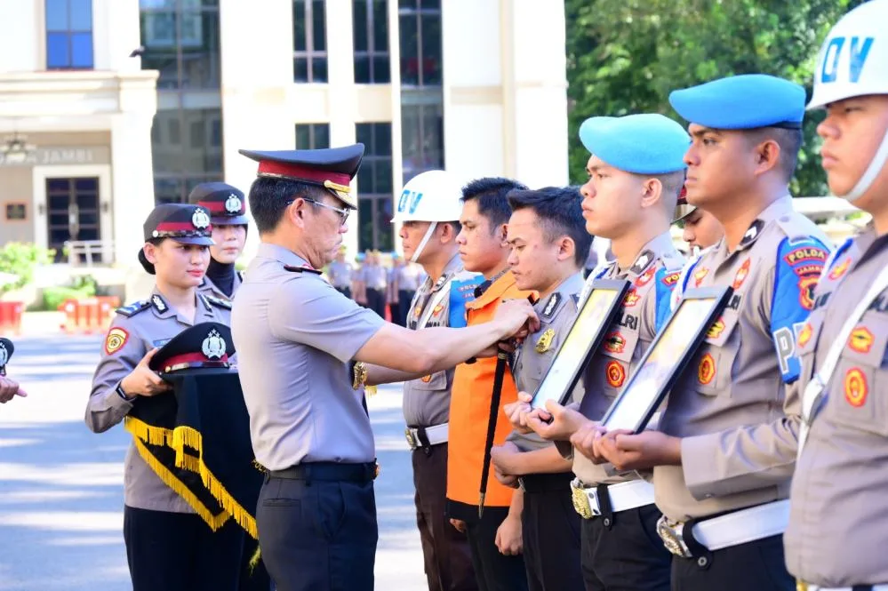Prosesi PTDH Anggota Polisi secar simbolis dengan penanggalan pakaian dinas kepolisian, sebelum keduanya mengenakan baju tahanan berwarna oranye di hadapan jajaran personel Polda Jambi.
