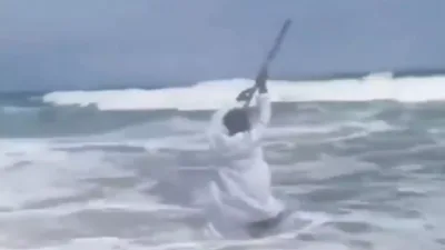 Dalam video tersebut, ia tampak sedang berdoa atau menyampaikan seruan tertentu sebelum ombak besar menghantam tubuhnya. Ia sempat berusaha mempertahankan keseimbangan sebelum akhirnya jatuh terseret air laut.