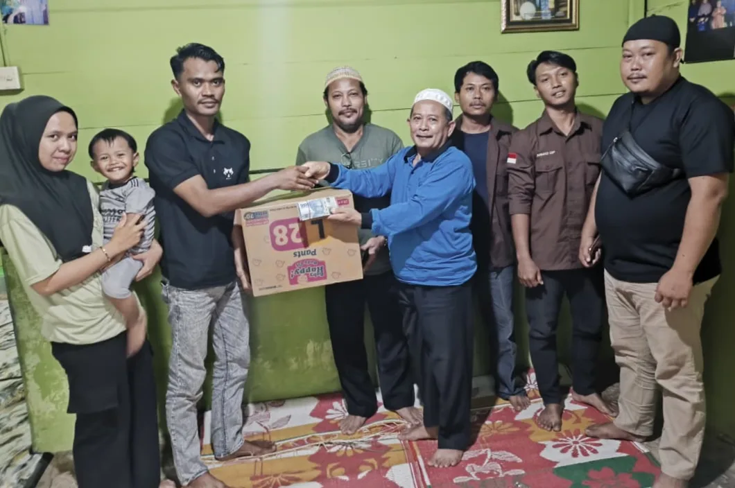 Karang Taruna Adi Pura Kencana bersama Pemerintah Desa Adi Pura Kencana menyerahkan donasi pakaian baru dan uang senilai *Rp14 juta* sebagai bentuk solidaritas antar-warga.